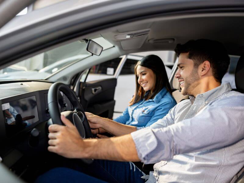 Couple test driving a car, man at the wheel