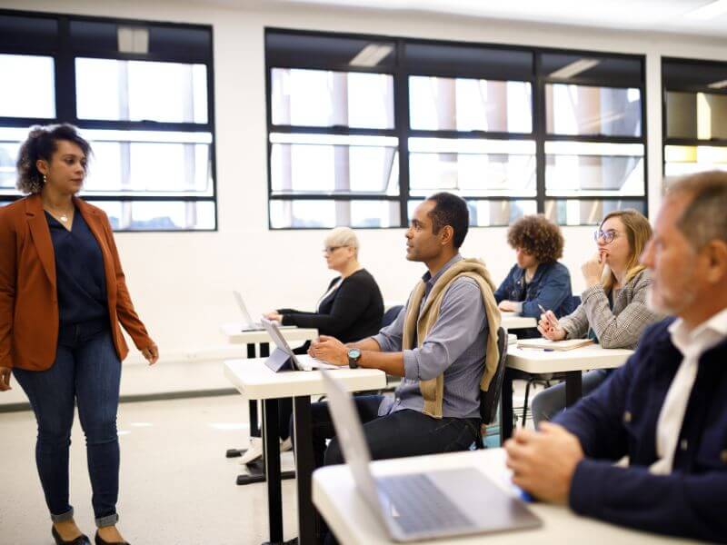 Adults attending a class in a bright seminar room