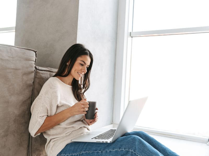 Woman relaxing with a laptop and a cup of coffee